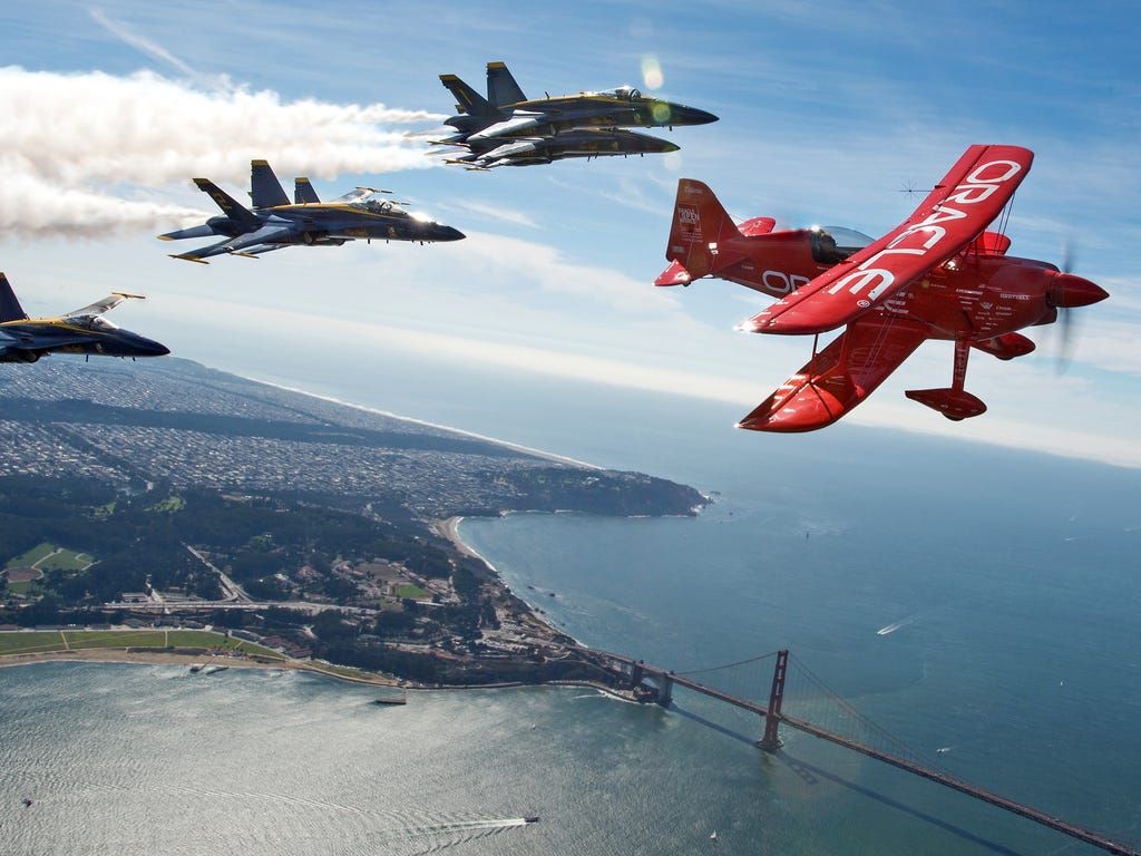 Team Oracle pilot Sean Tucker  flies ahead of the U.S. Navy Blue Angels as part of a practice run for Fleet Week over the bay in San Francisco.
