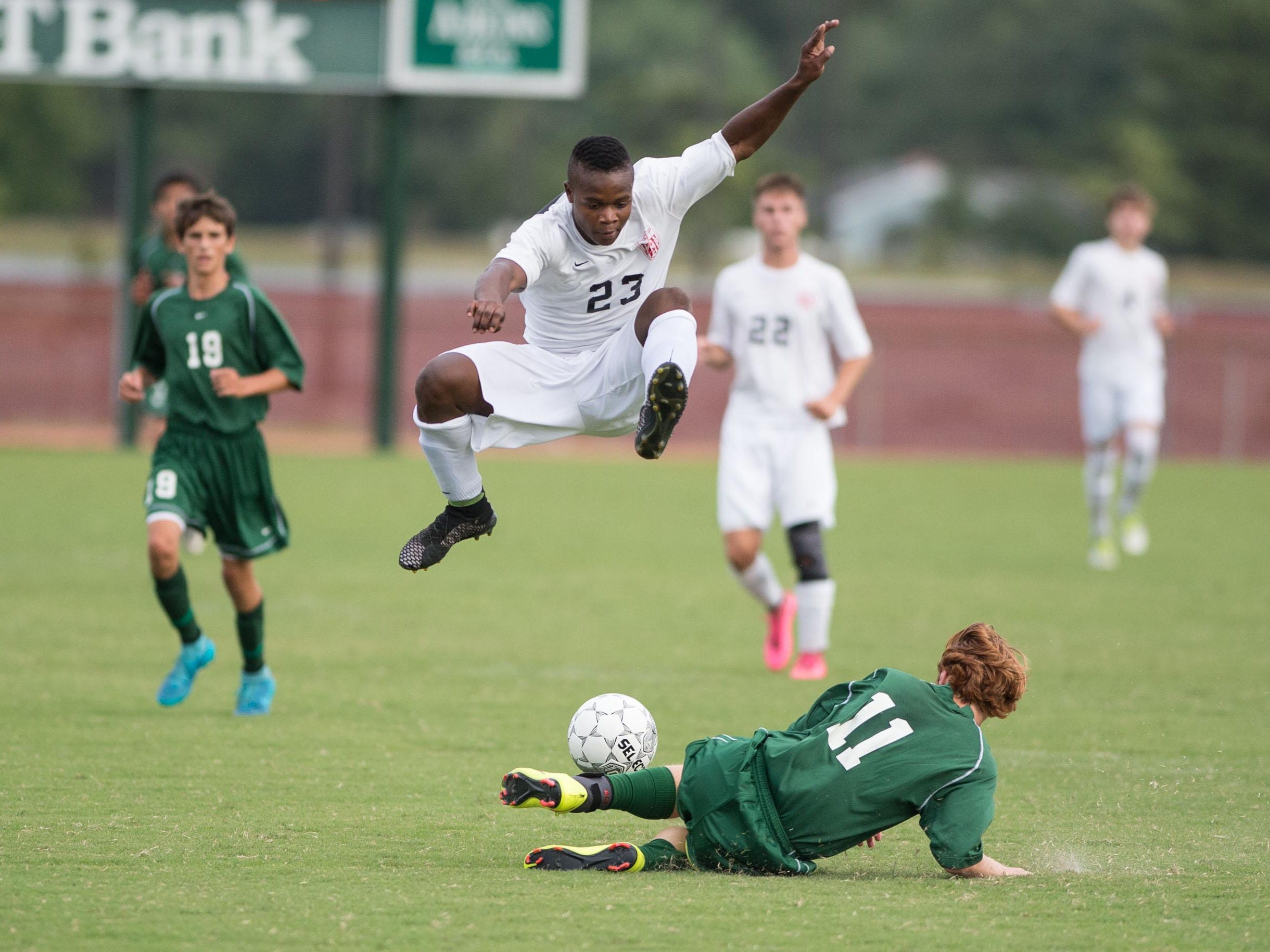 JMB’s Cermy Oneus leaps over Parkside’s Max Corry after a slide tackle.