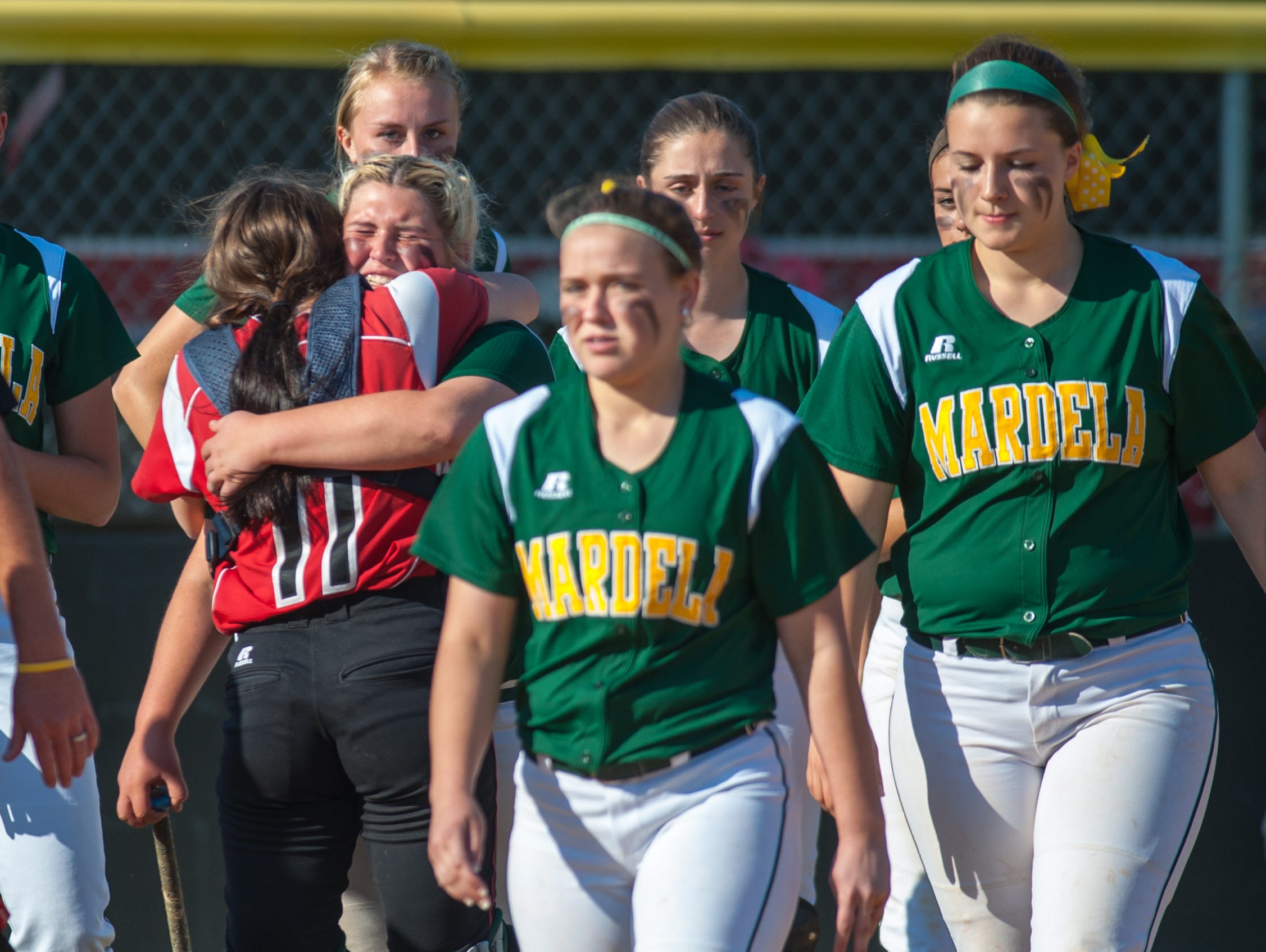 Mardela third baseman Kasey Goshorn (15) and Colonel RIchardson catcher Emily Cox (11) share a hug following the Warriors 2-1 loss in the MPSSAA 1A East Softball Region Finals on Friday afternoon in Federalsburg.