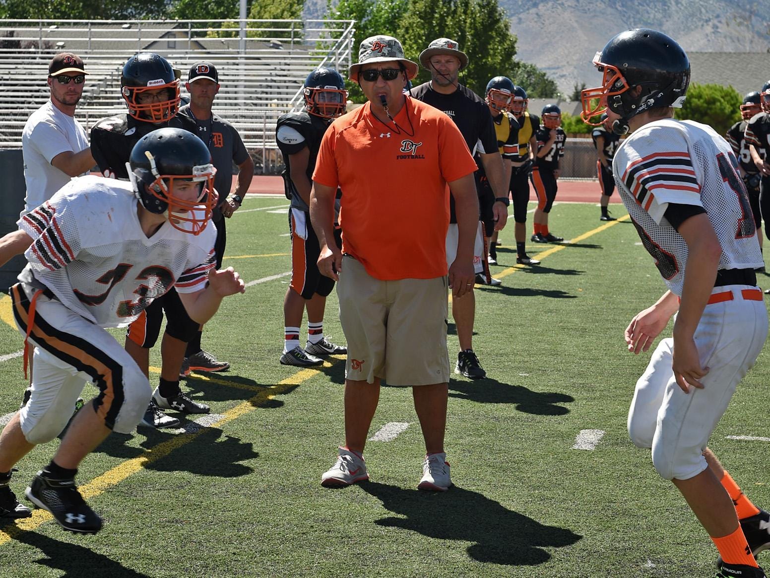 Douglas football coach Ernie Monfiletto, center, watches as his team goes through tackle drills during practice on Aug.