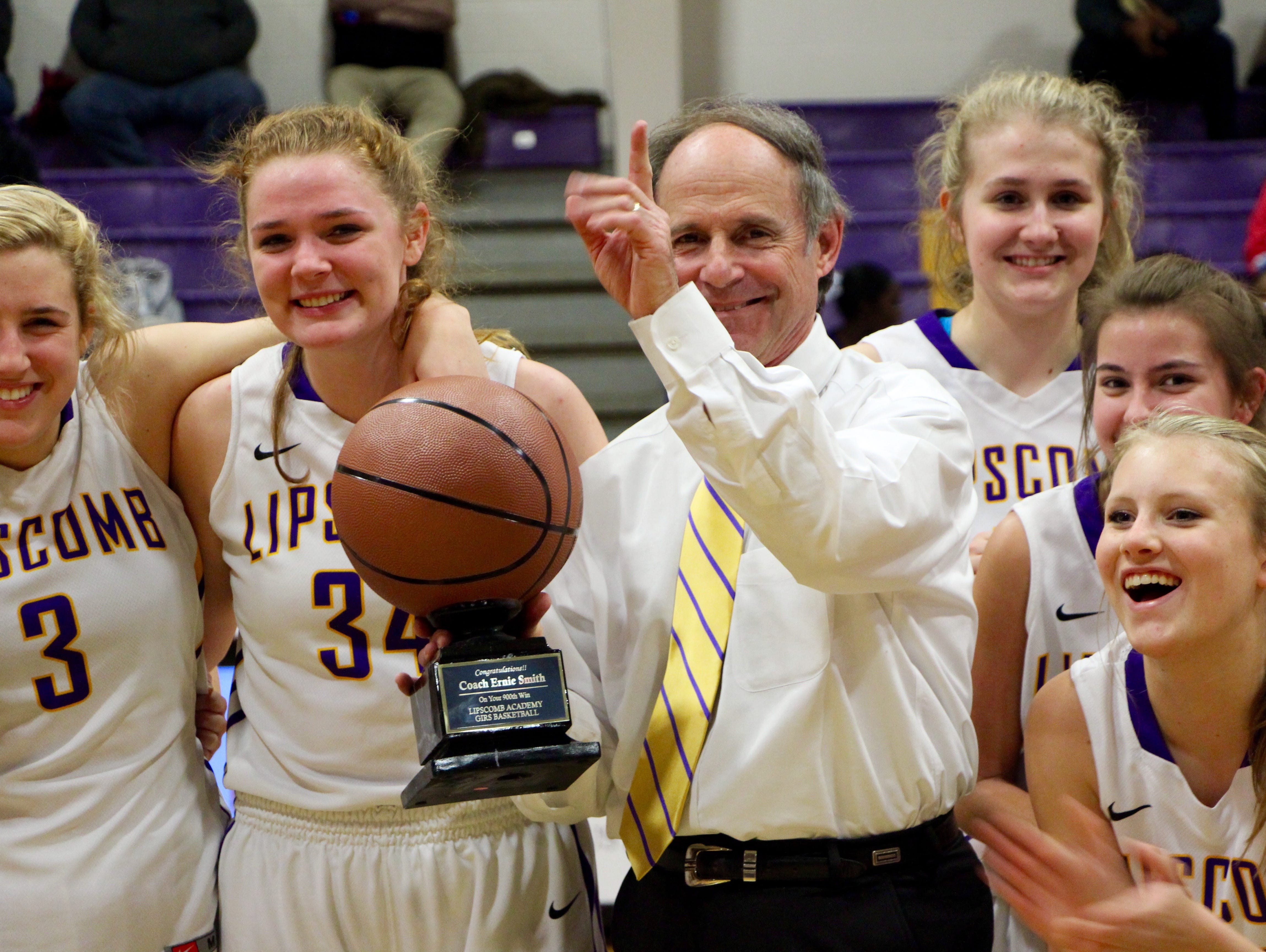 Lipscomb Academy girls basketball coach Ernie Smith celebrates with players following a 51-28 win over Martin Luther King Magnet School Tuesday, earning Smith his 900th basketball coaching victory.