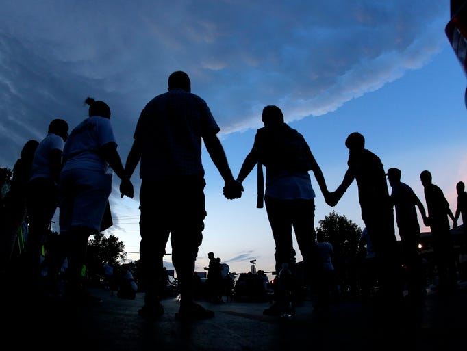 People pray after marching about a mile to the police station to protest the shooting of teenager Michael Brown on Aug. 20 in Ferguson, Mo. Brown's shooting on Aug. 9 by a Ferguson police officer has sparked a more than week of protests, riots and looting in the St. Louis suburb.