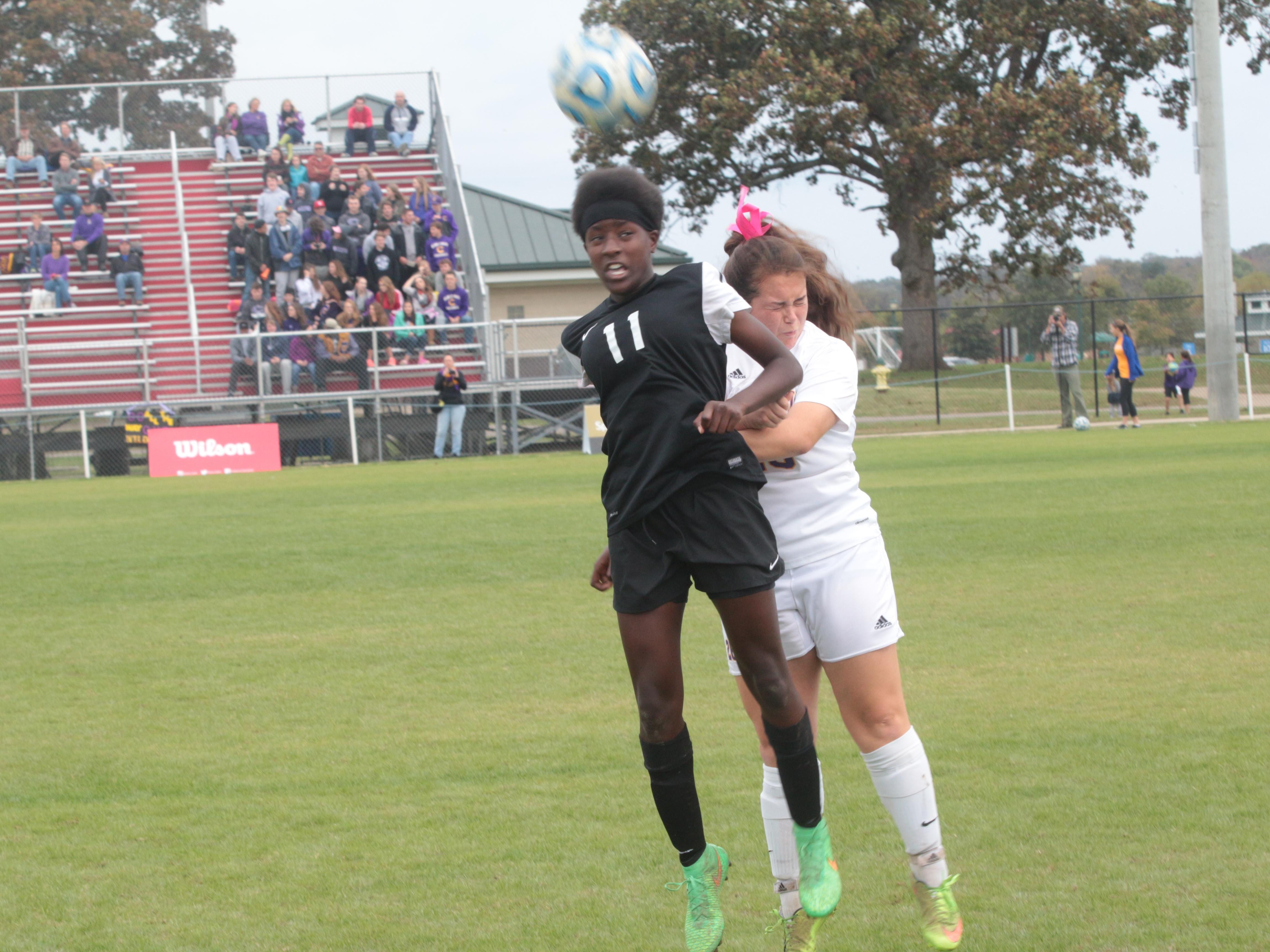 Houston’s Paola Ellis (11) heads the ball away from Clarksville’s Staci Navarro in the first half of Saturday’s game.