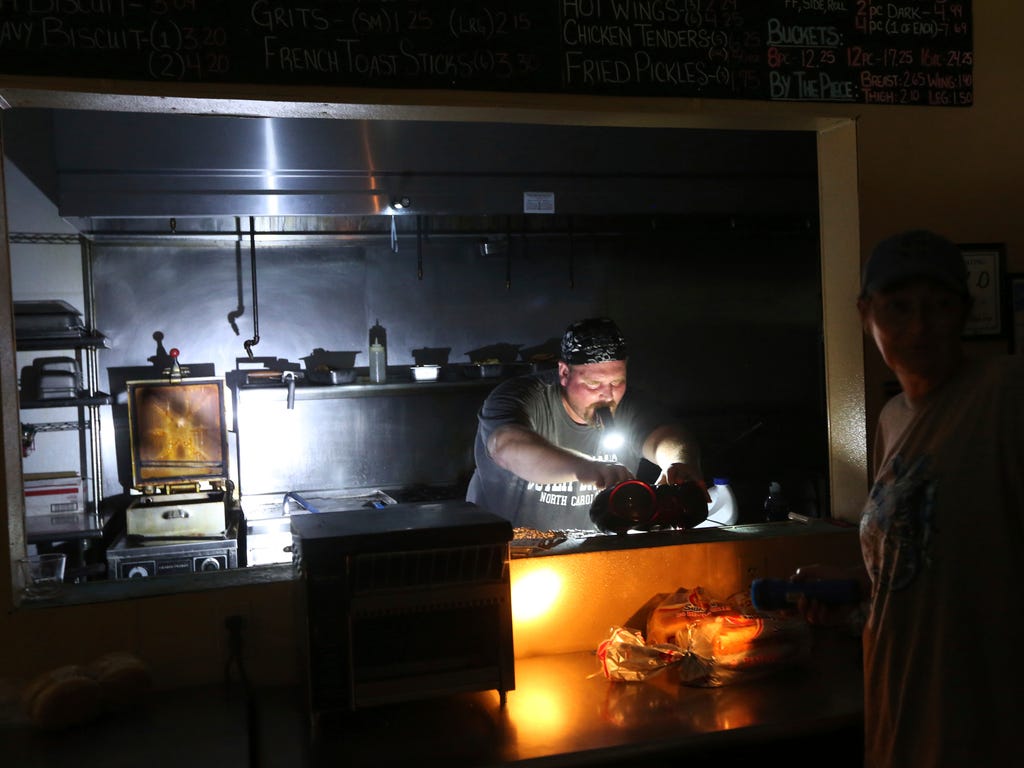 Aaron Howe cooks in a dark kitchen at the Island Convenience Store in Rodanthe on Hatteras Island, N.C. About 10,000 tourists face a noon deadline Friday for evacuating the island on North Carolina's Outer Banks after a construction company caused a 
