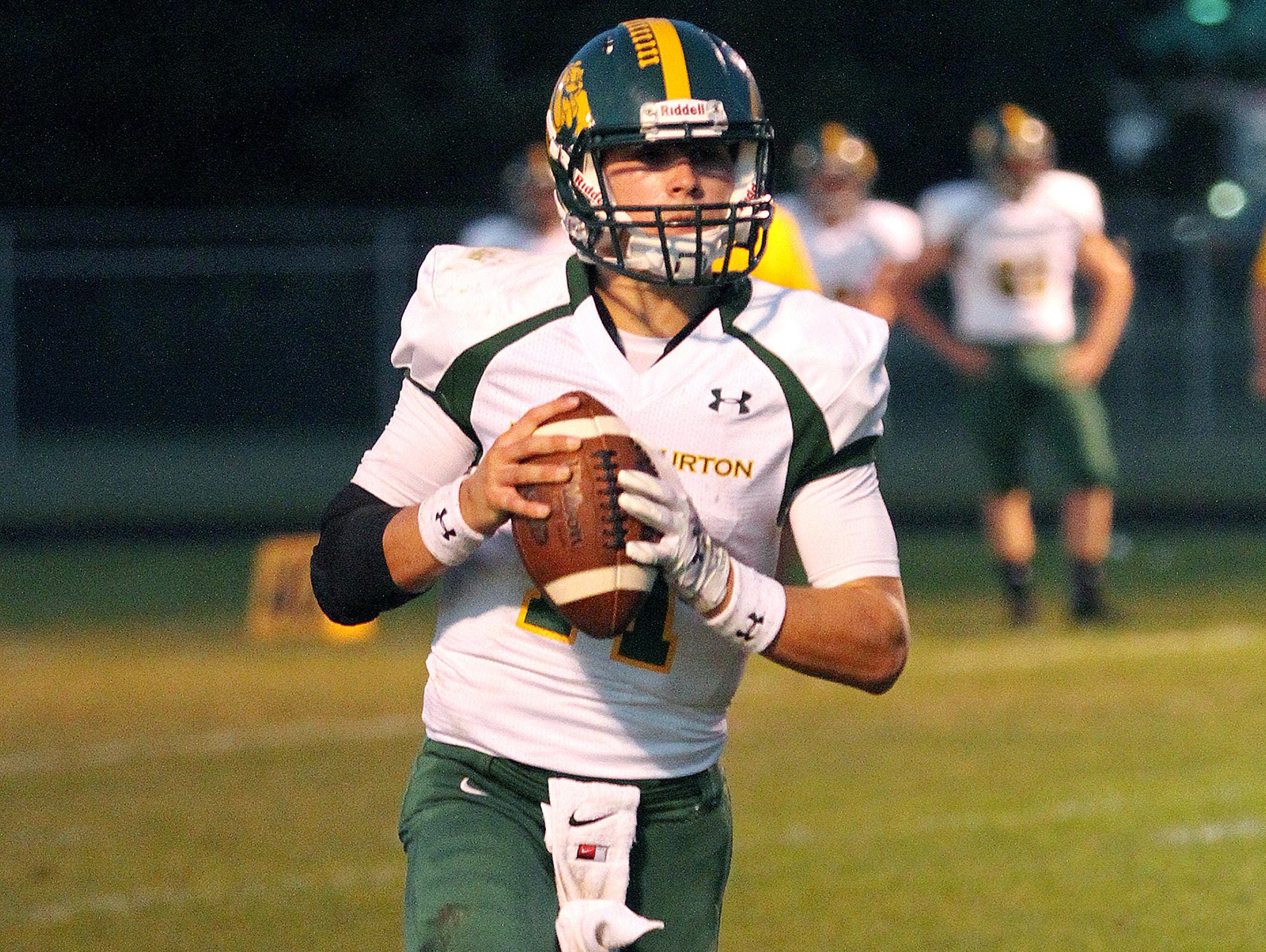 Burr and Burton quarterback Griff Stalcup rolls out of the pocket during a Week 3 football game against Milton.