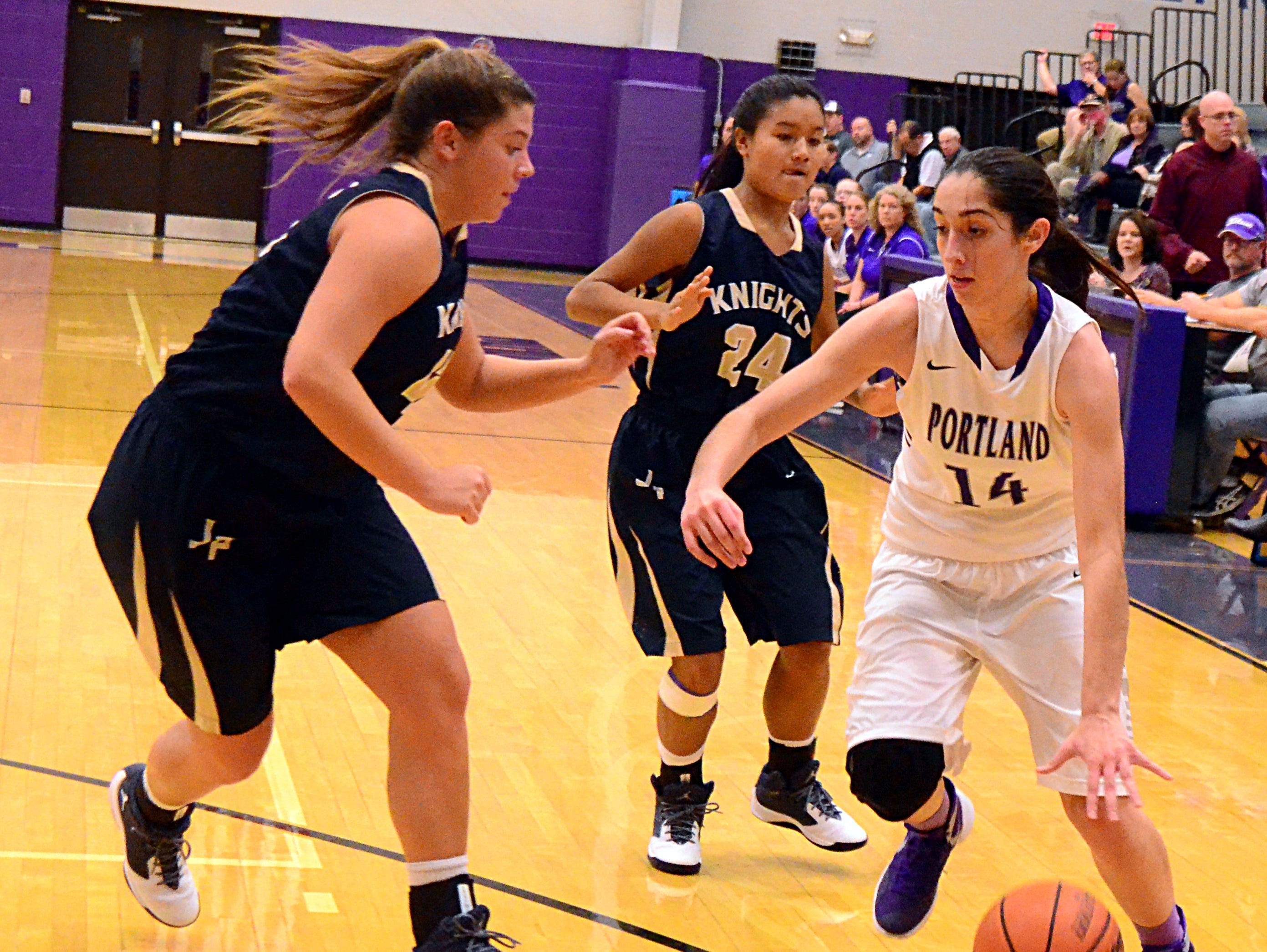 Portland High junior Mackenzie Trouten (14) dribbles to the basket as Pope John Paul II seniors Windee Johnson and Mercedes Smith (24) converge during first-quarter action. Trouten scored a career-high 17 points in the Lady Panthers' 52-37 victory on Tuesday evening.