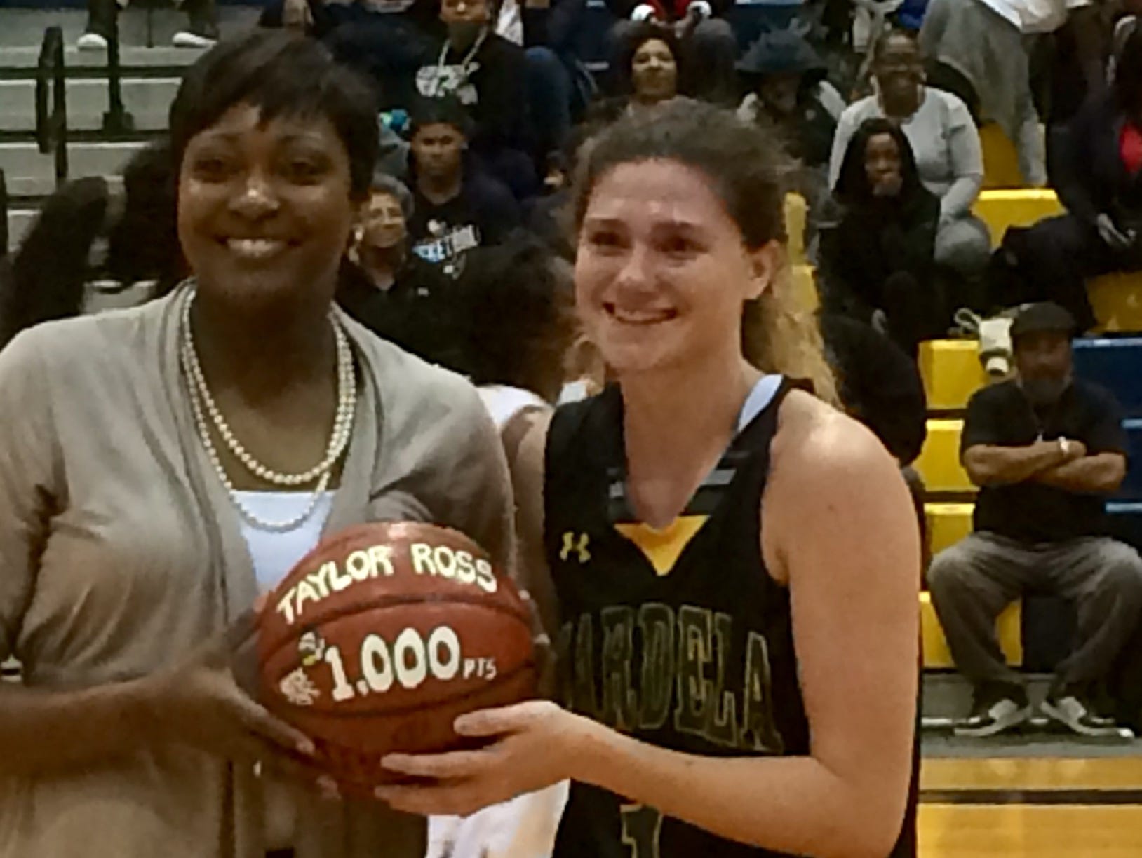 Mardela head coach Kesha Cook presents Taylor Ross with a commemorative ball after she scored her 1,000th point.