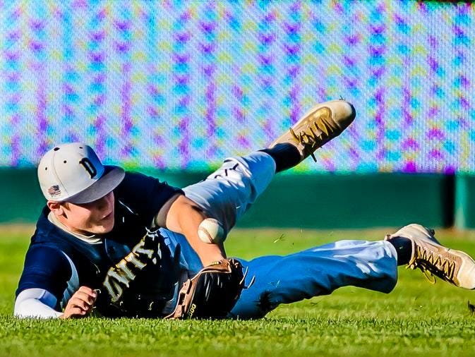 Michael Stygles of DeWitt dives for a basehit by Xavier Farr of Grand Ledge in the top of the 6th inning of their Diamond Classic semifinal game Monday June 6, 2016 at Cooley Law School Stadium in Lansing.