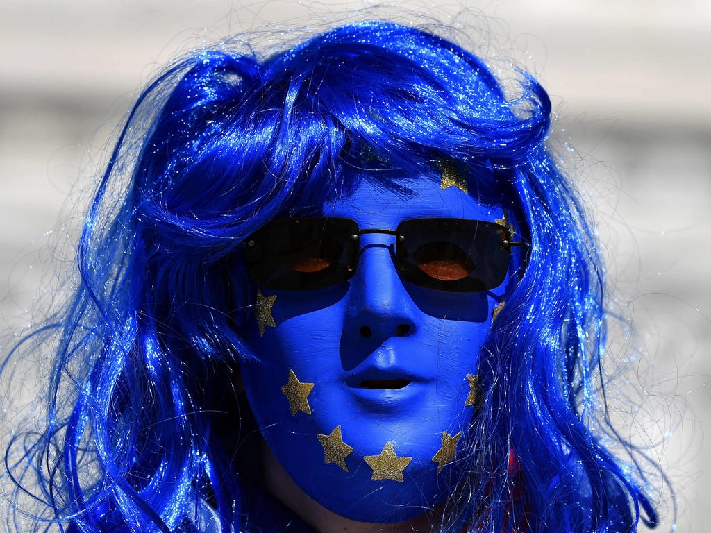 An anti-Brexit protester wears a mask with the stars of the European Union flag on it in Florence, Italy, where British Prime Minister Theresa May is to speak.
