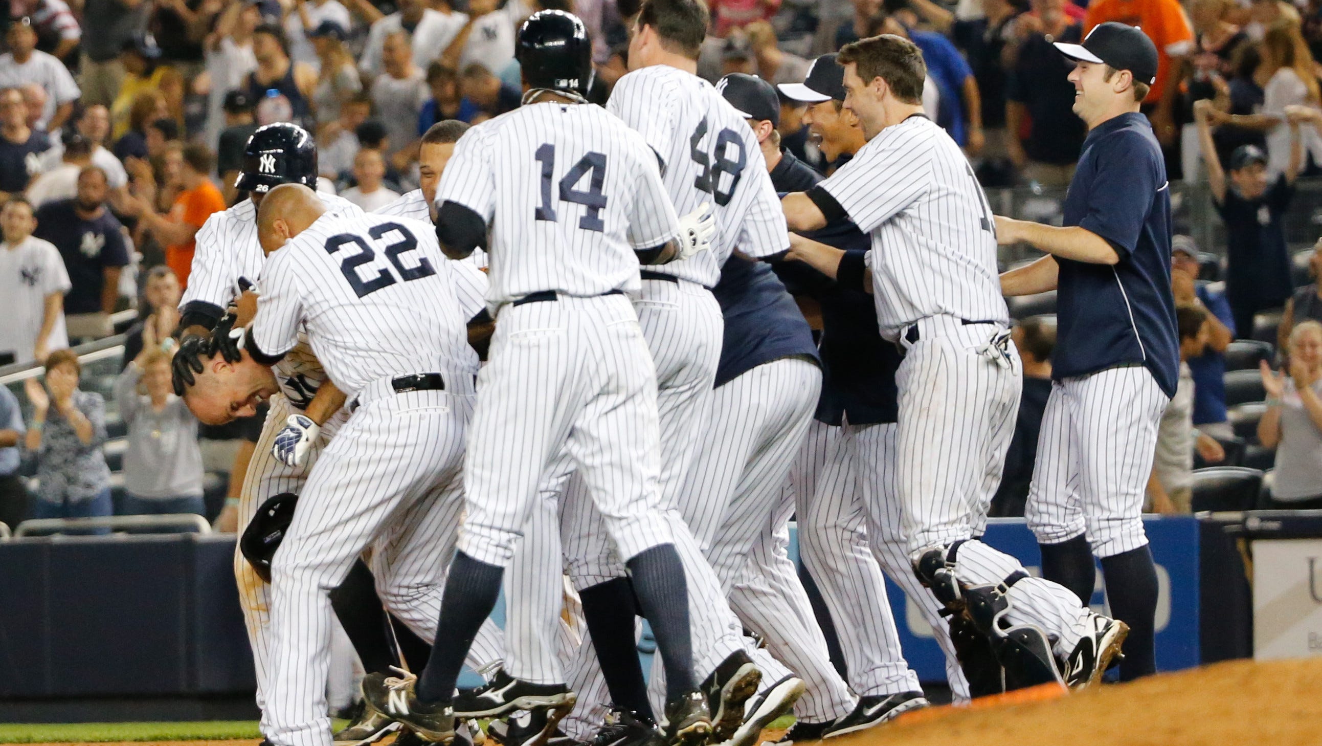 Aug. 9: Teammates mob Yankees center fielder Brett Gardner after his walk-off single in the 10th tenth inning against the Tigers at Yankee Stadium.