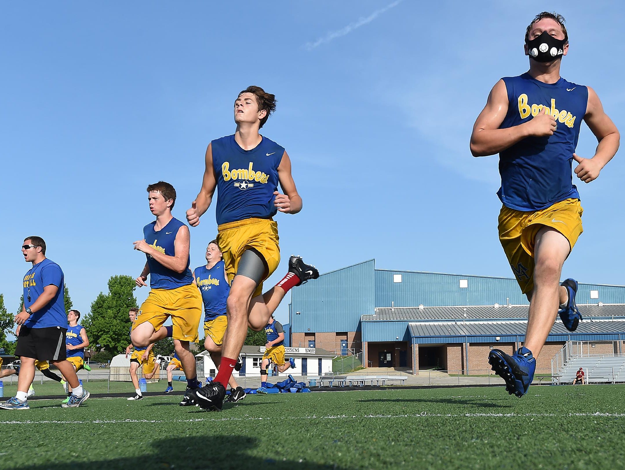 Bomber football players Riley Peters, right, and Peyton Hughes run a sprint drill Tuesday. The team is practicing several times a week this summer on a voluntary basis.