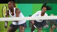 Serena Williams (USA) hits the ball as Venus Williams