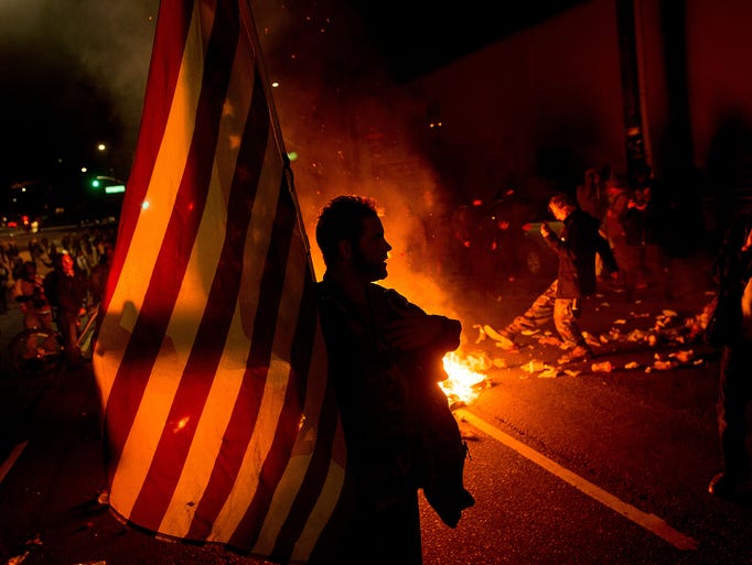 James Cartmill holds an American flag while protesting