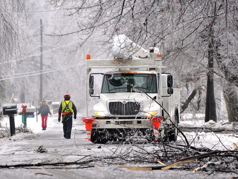 A utility truck is parked on a street to help restore power to a neighborhood in North Lansing, Mich., on Dec. 22, 2013.