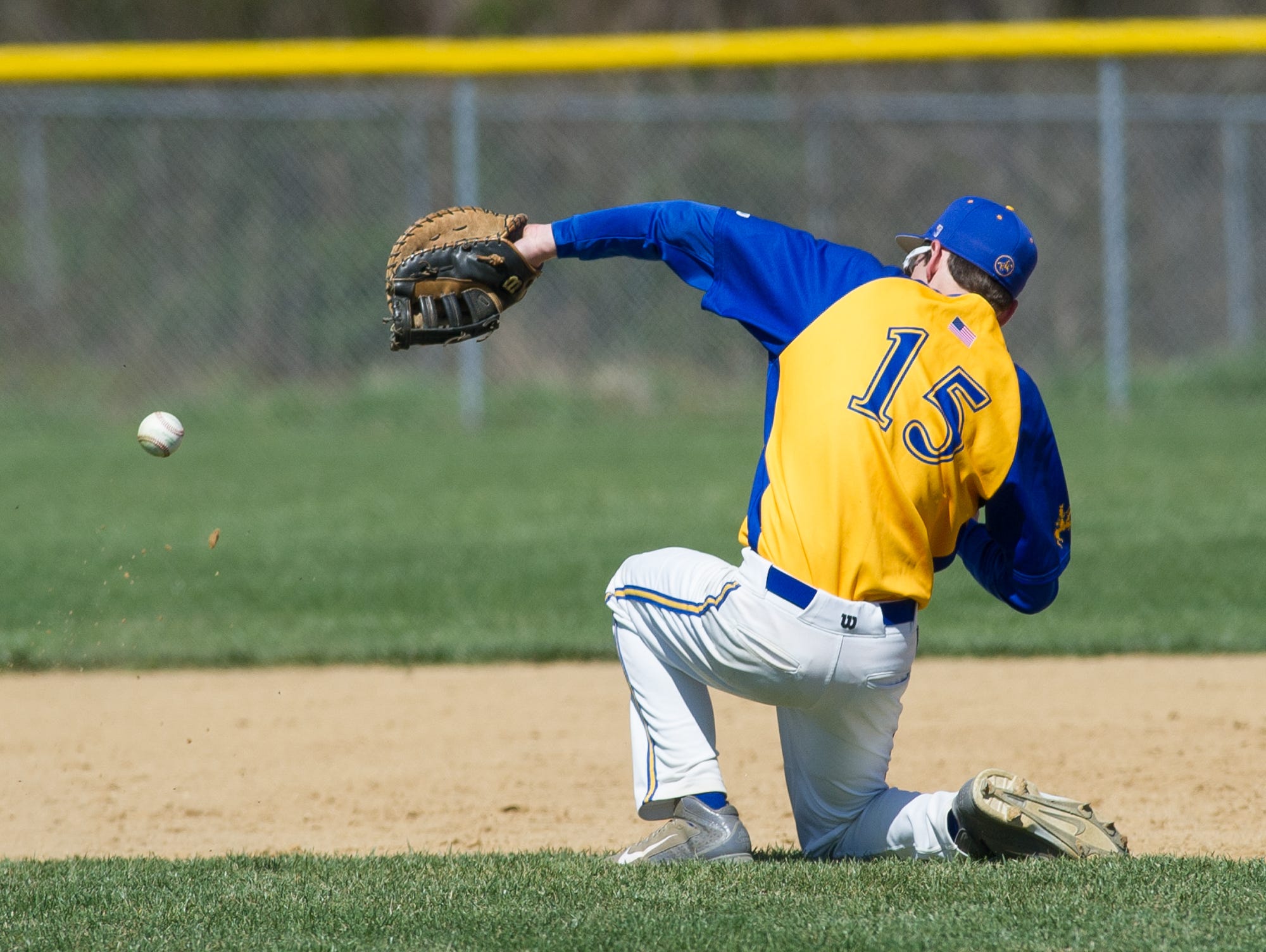 Caesar Rodney's first baseman Robert Williams (15) tries to stop a infield hit in their game against St. Marks.