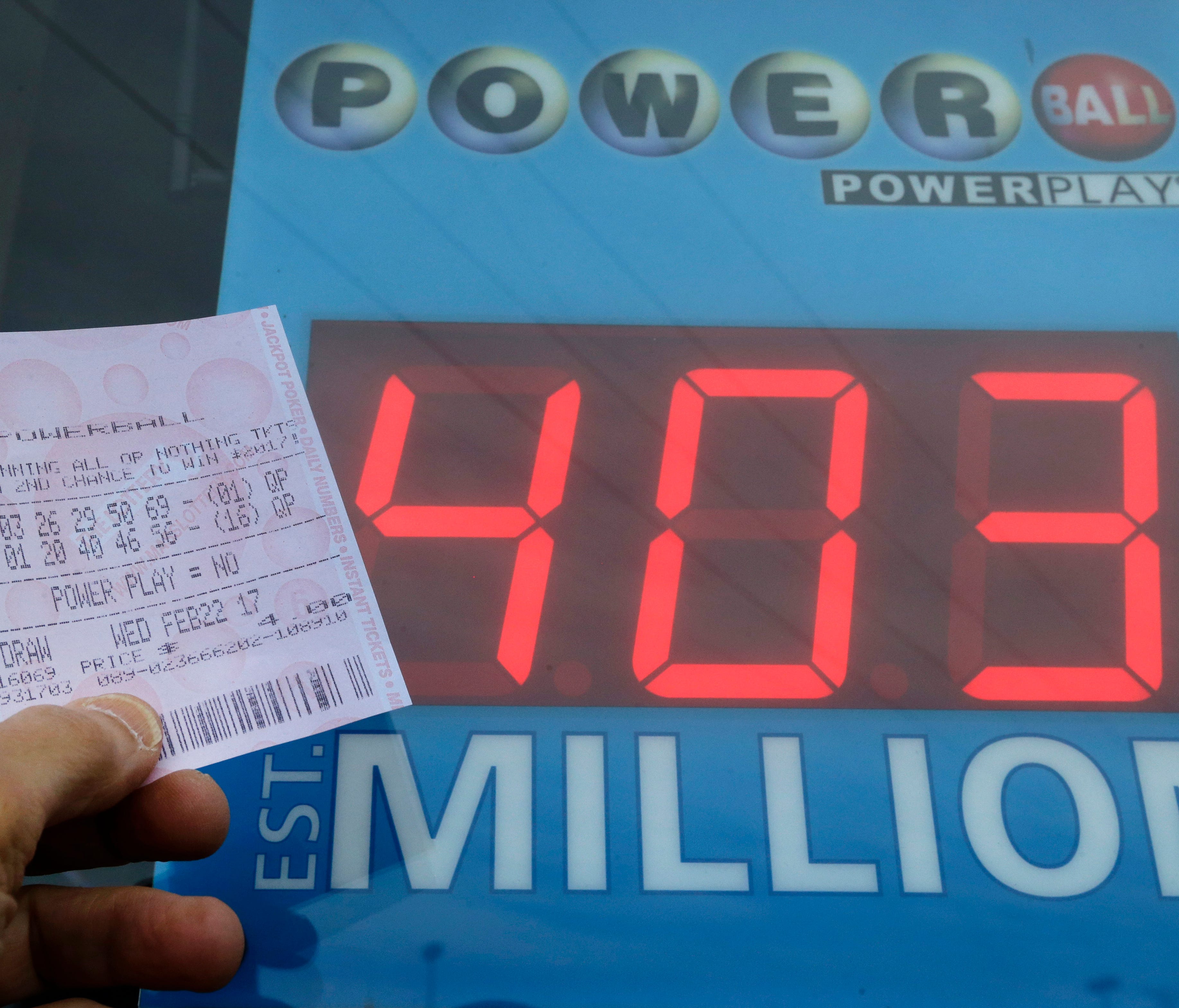 A Powerball quick-pick ticket is pictured near a sign displaying the jackpot amount in Methuen, Mass. The Powerball jackpot has climbed above $400 million for the first time in nearly three months.