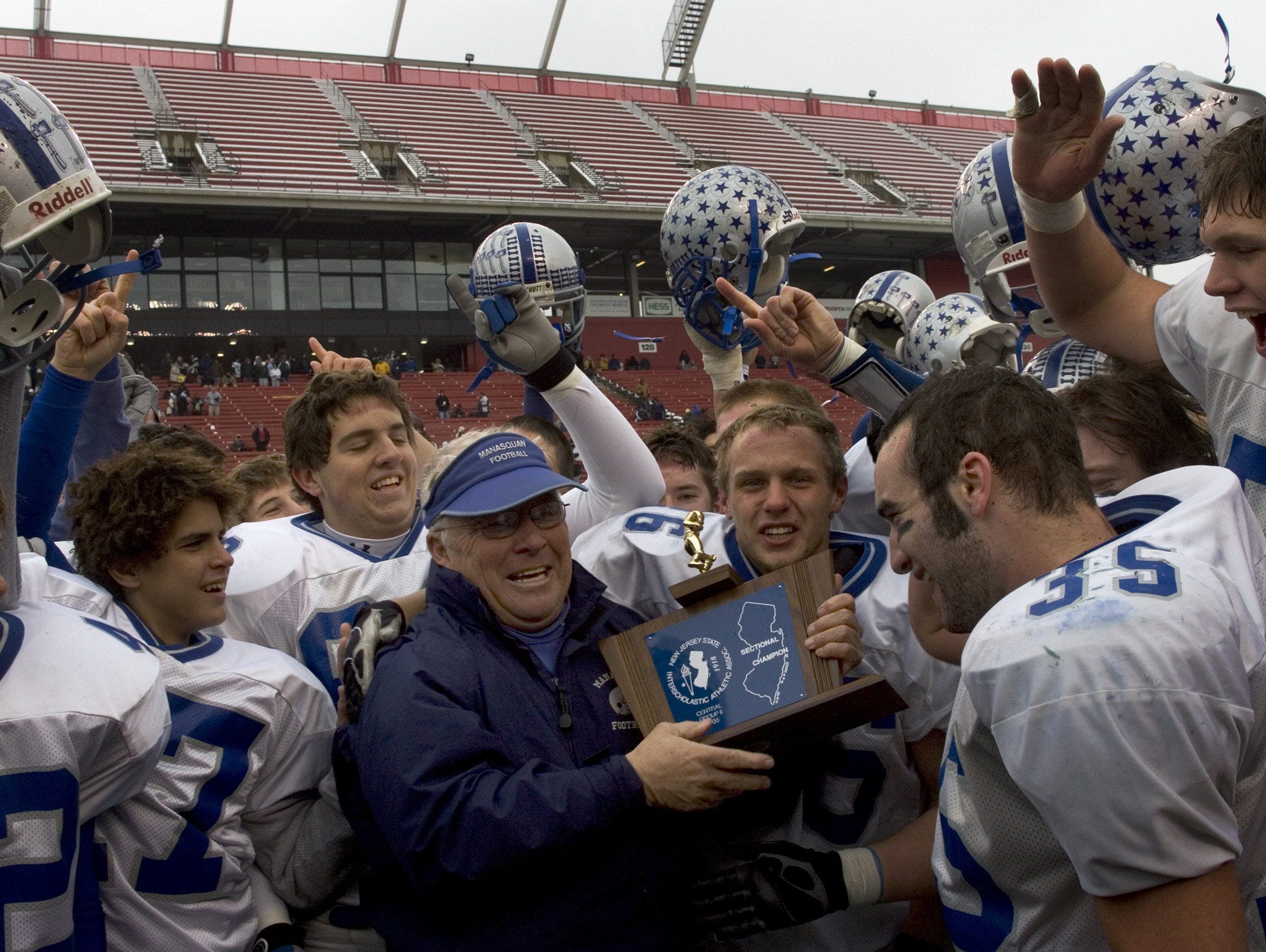 Manasquan coach Vic Kubu holds up championship trophy in 2005. Kubu coaches seven teams to unbeaten seasons over the years.