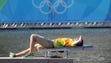 An Olympic volunteer rests during a wind delay for