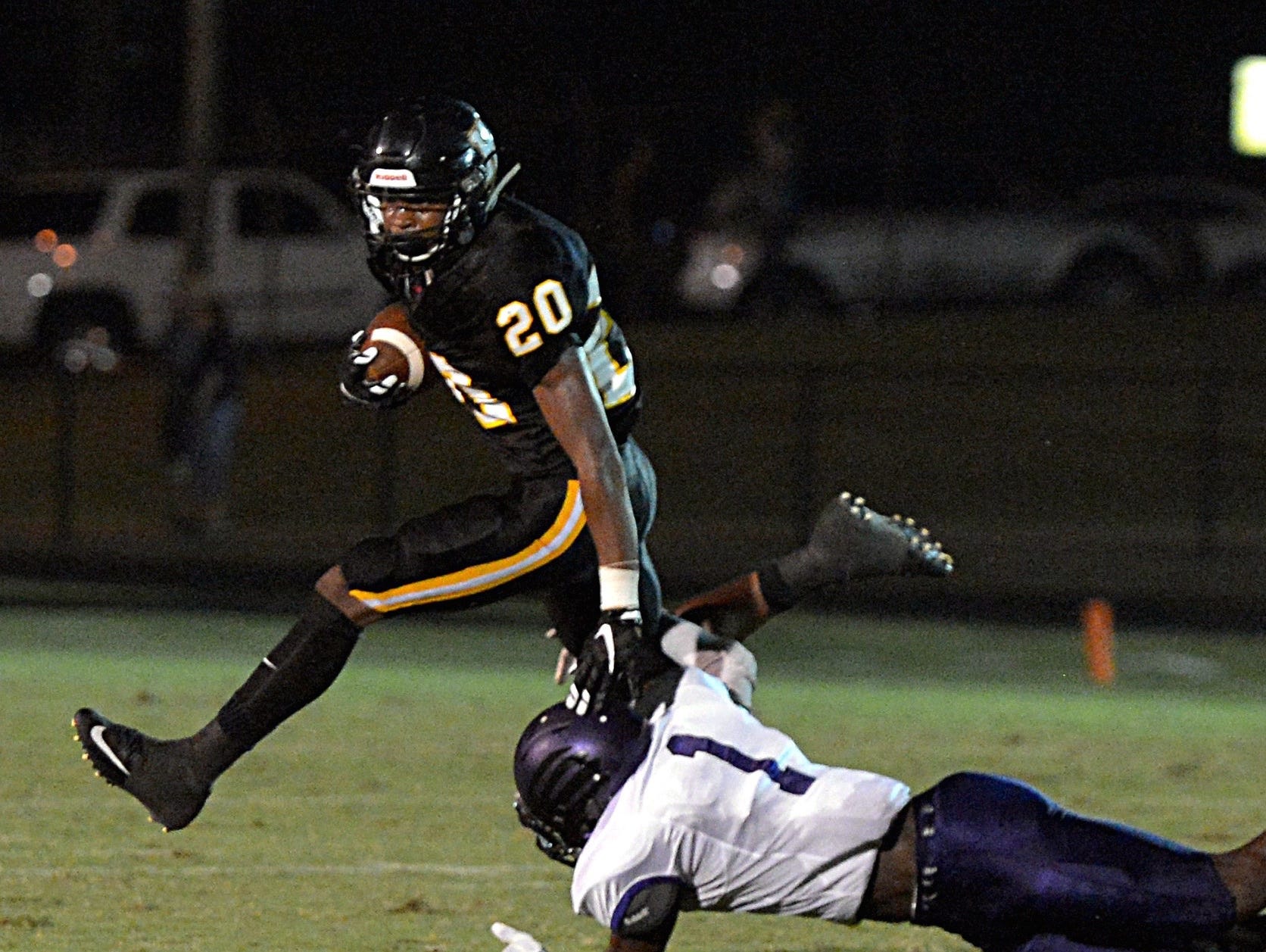 Hendersonville High junior running back Terrell Carter (20) attempts to break a tackle from Cane Ridge senior Austin Jackson during the teams' Sept. 4 contest.