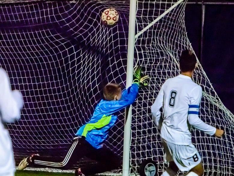 Quinton Hay ,8, of East Lansing watches his kick sail into the net past St. Johns goalie Brett Post to put East Lansing up 3-0 in the 2nd half of their Division 2 district semifinal game Thursday October 22, 2015 in East Lansing.