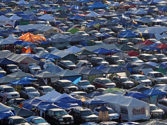 In an aerial view, tents line the on-site camping area