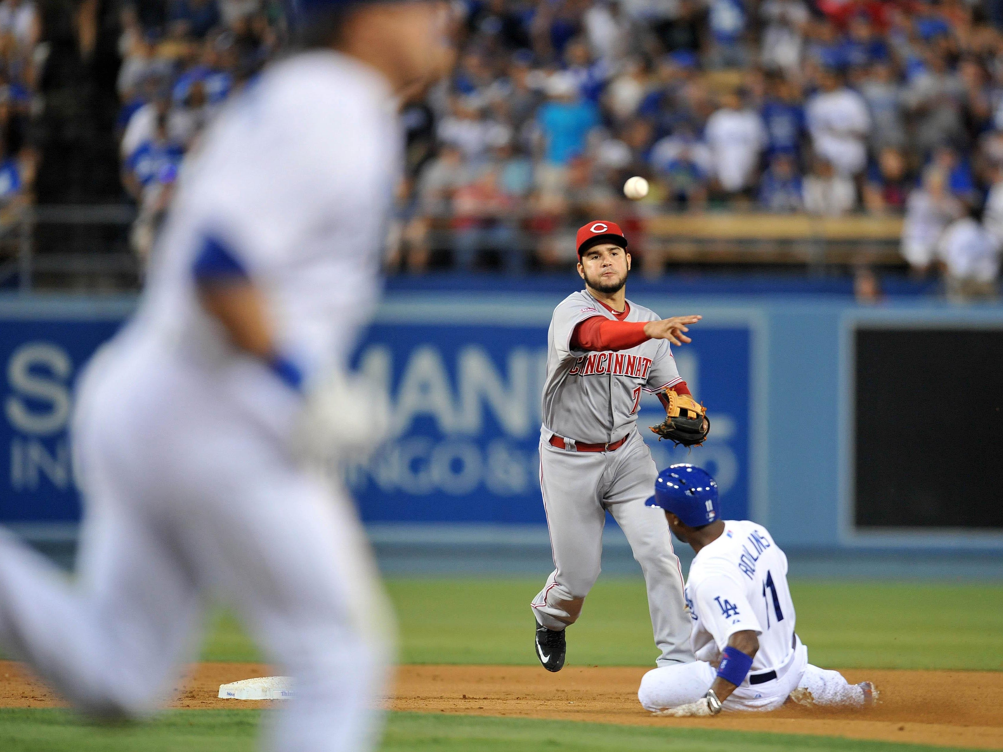Cincinnati shortstop Eugenio Suarez throws to first base to turn a double play in the sixth inning against Los Angeles on Saturday night at Dodger Stadium.