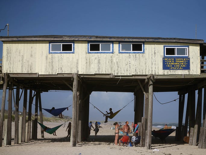 People hang out under the old Hatteras Pier in Cape Hatteras.