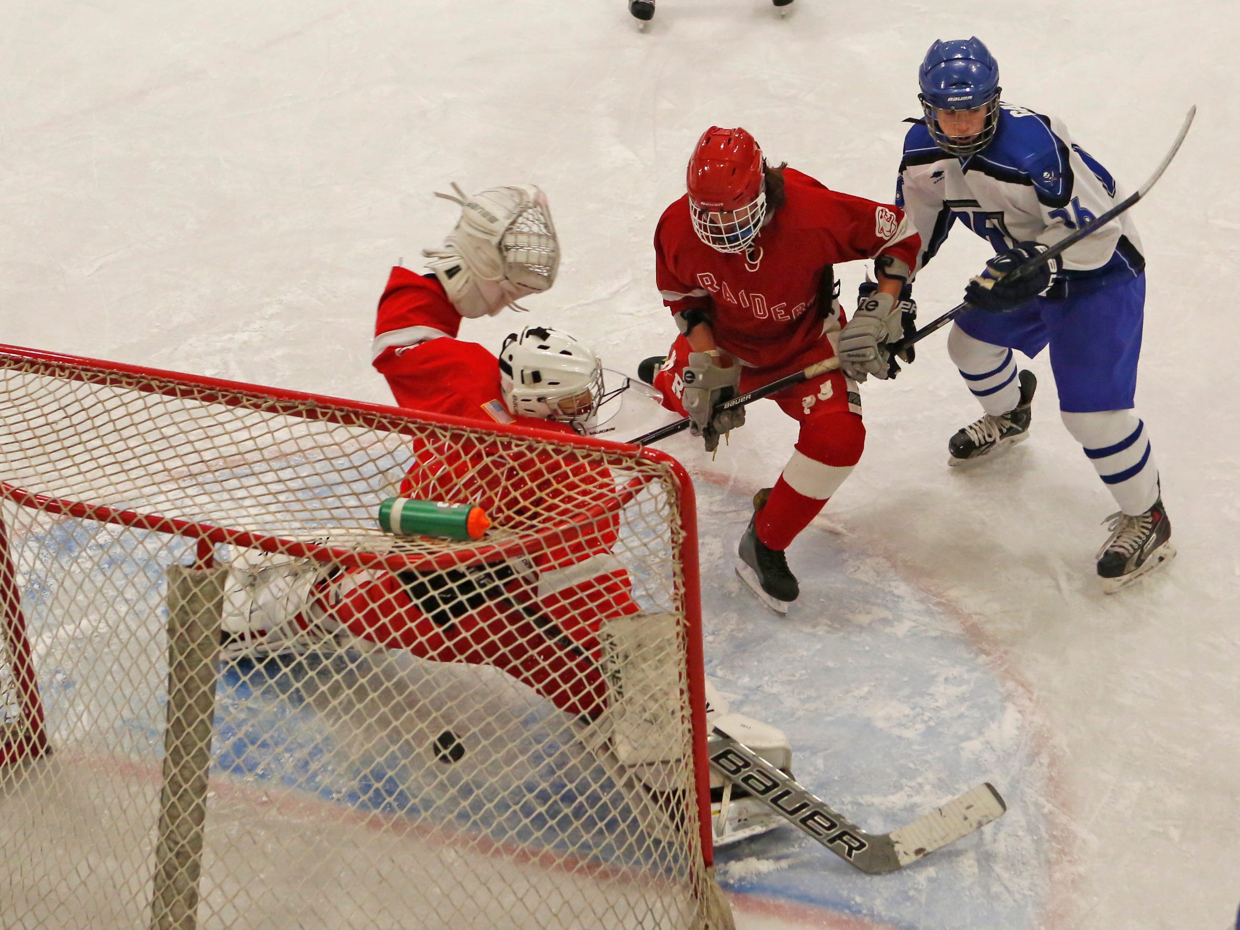 Pearl River’s Michael Galgano, in blue, scores against North Rockland goalie Kenny Hoppe while being checked by Nico Zodda in the first period Sunday at Sport-O-Rama in Monsey.