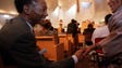 Gil Hill shakes hands with a congregation member at