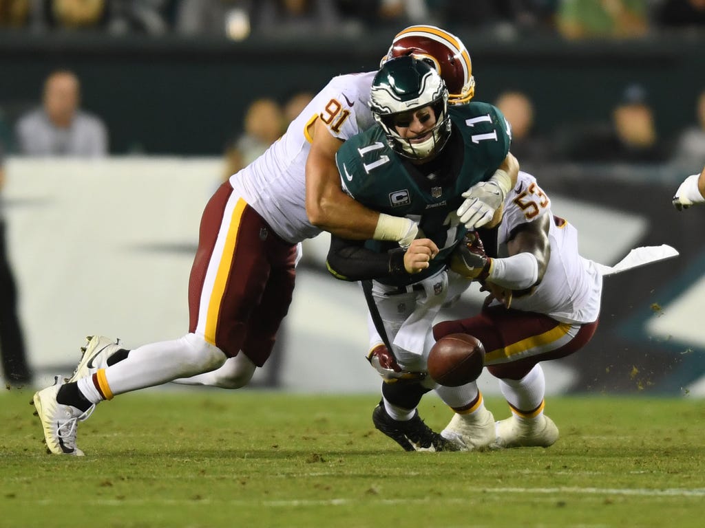 Philadelphia Eagles quarterback Carson Wentz is sacked by Washington Redskins linebacker  Ryan Kerrigan, left, and linebacker  Zach Brown, right, in the second quarter at Lincoln Financial Field in Philadelphia.