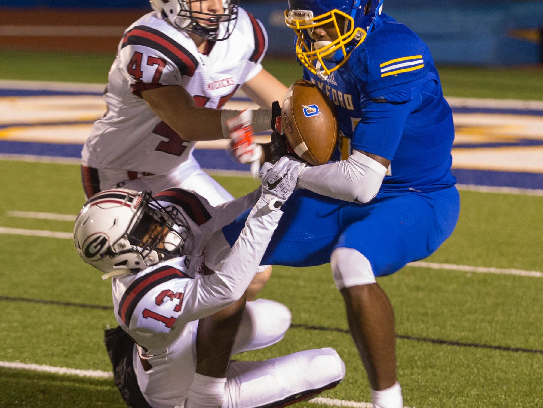 Germantown's Jacob Mangino (47) and Nigel Knott (13) try to stop Oxford's DK Metcalf in Friday's playoff game.