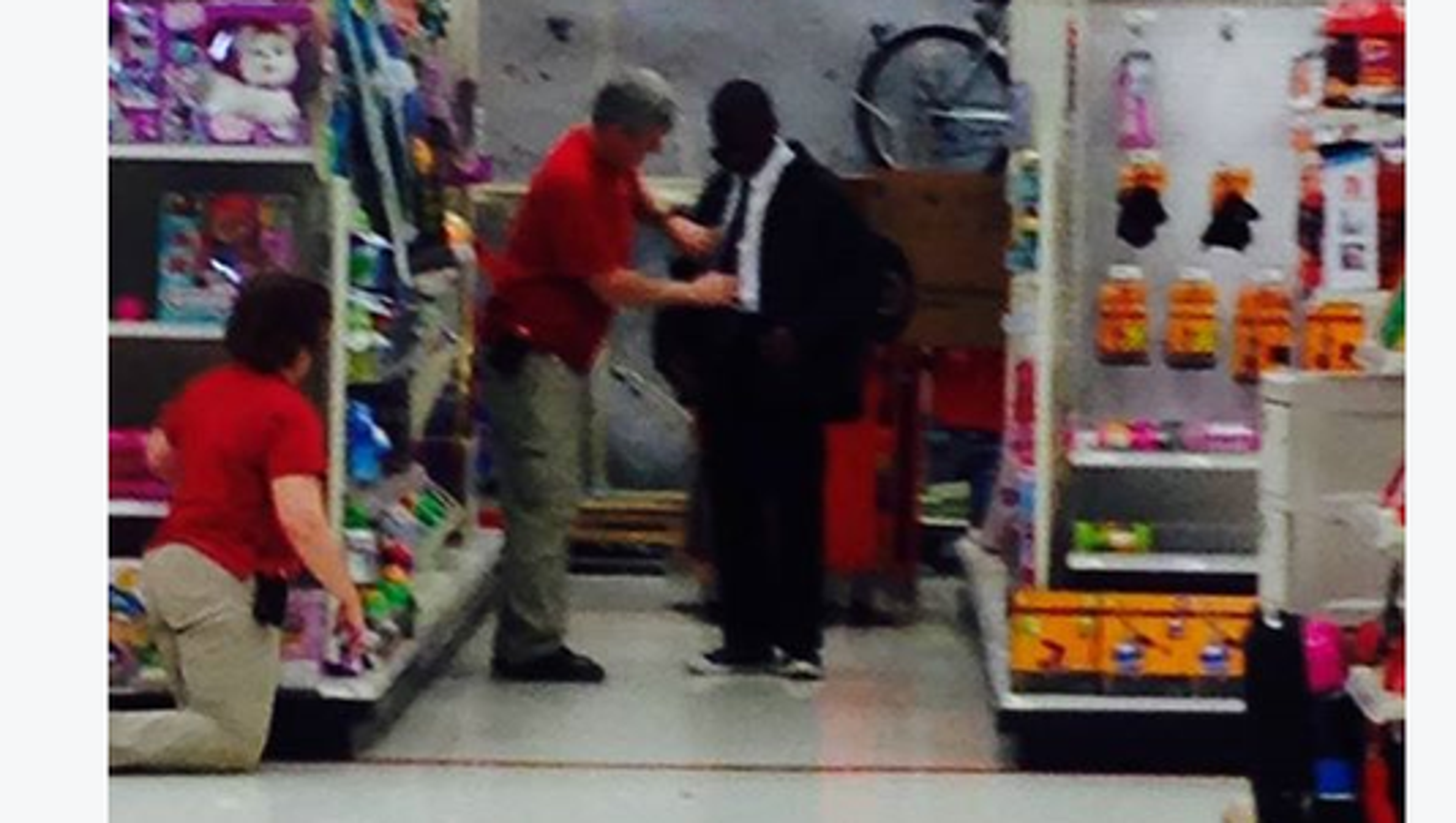 Target worker helps young man tie a tie for interview