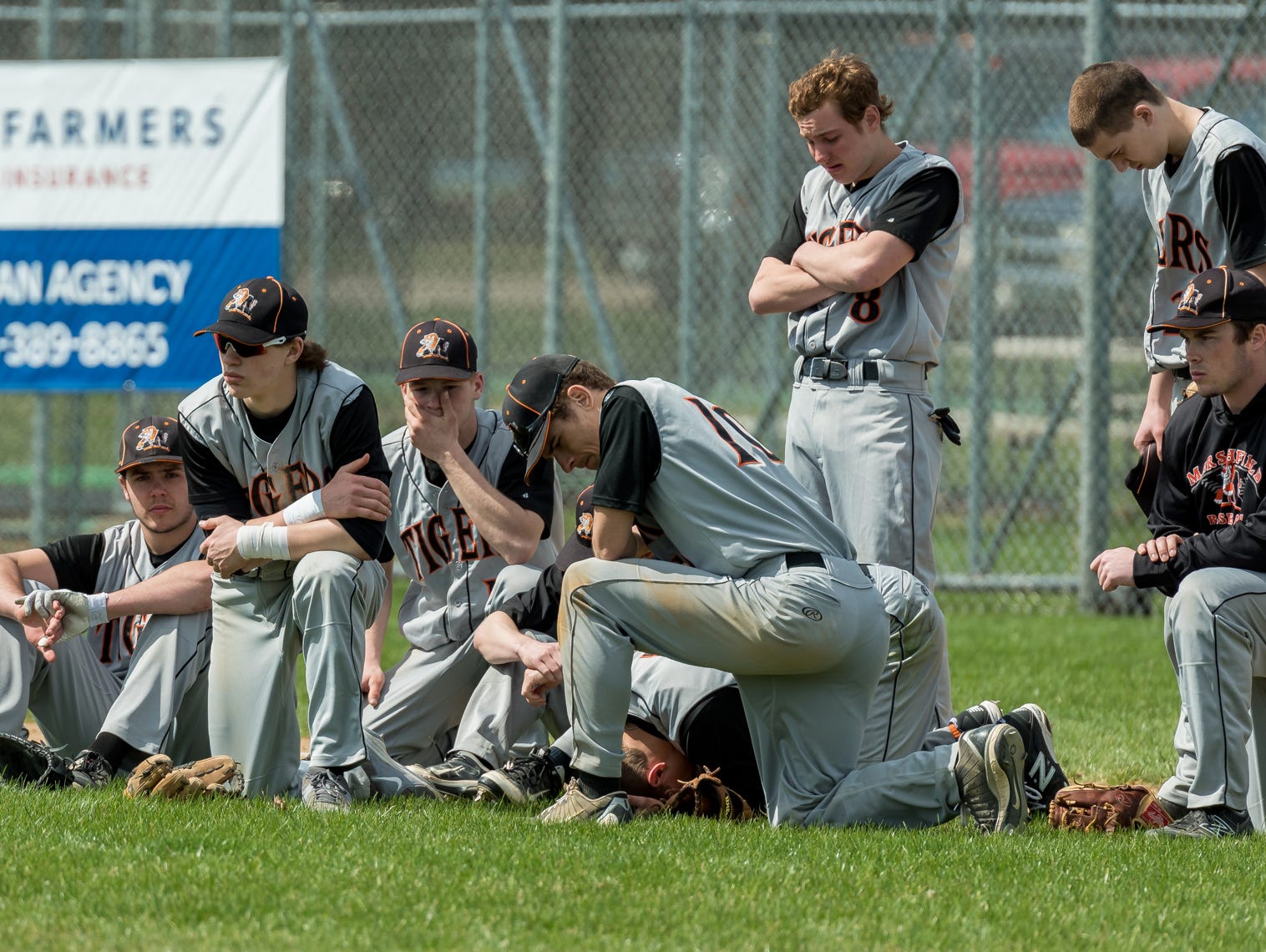 The Marshfield High School baseball team reacts Saturday after teammates Trevor Schwecke, 17, and Braden Bohman, 15, collided during a game against Chippewa Falls at Jack Hackman Field in Marshfield.