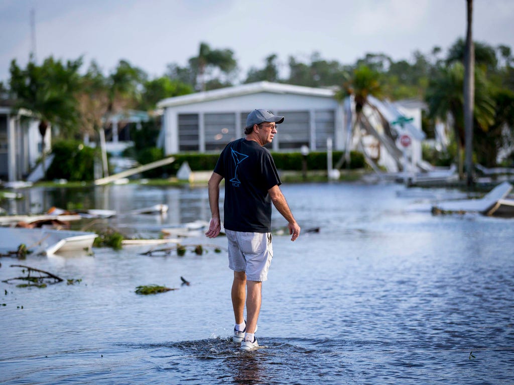 Steve Jewell, 52, walks through flooded streets at Naples Estates trailer park in East Naples, Fla., on Sept. 11, 2017.