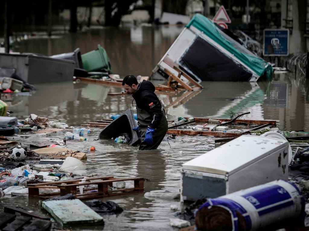 A resident cleans debris from a flooded street in Villeneuve-Saint-Georges, south of Paris, on Jan. 25, 2018.\u000d\u000aThe Seine continued to rise on Jan. 25, 2018, flooding streets and putting museums on an emergency footing as record rainfall pus