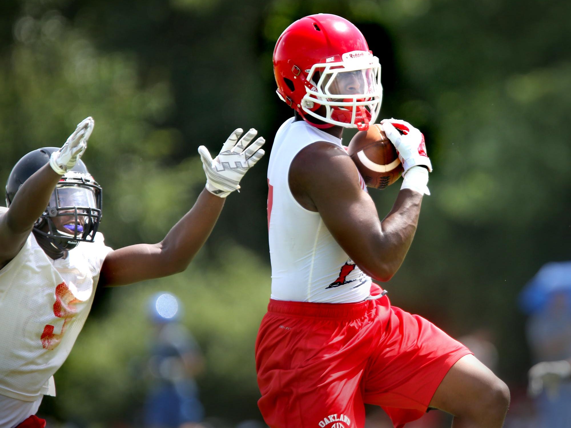 Oakland’s JaCoby Stevens jumps to make a catch as a Stewarts Creek defender tries to stop him during the Bojanbles 7-on-7 Passing Tournament at Riverdale. Oakland finished runner-up to Marshall County.