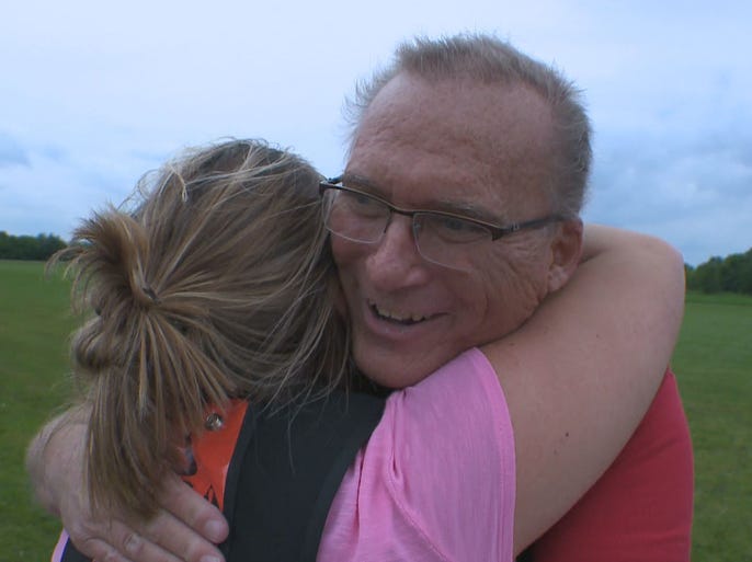 Brian gets a hug from his daughter. Both Katie and Nicole complete a jump with their father.
