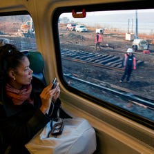 Passengers on a Metro-North train view ongoing repair work near the Bronx station where a train derailed Sunday.