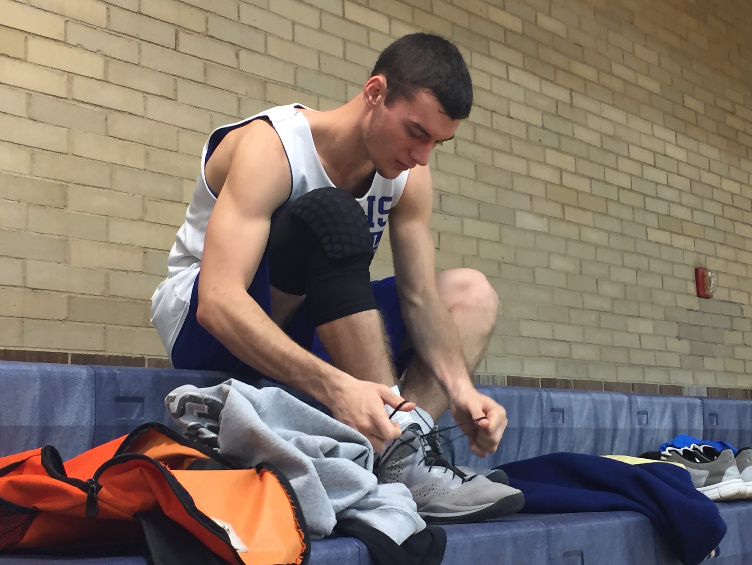 Burris senior Ryan Morey unties his shoes after practice. Burris has early practices, usually starting at 5:45 a.m.