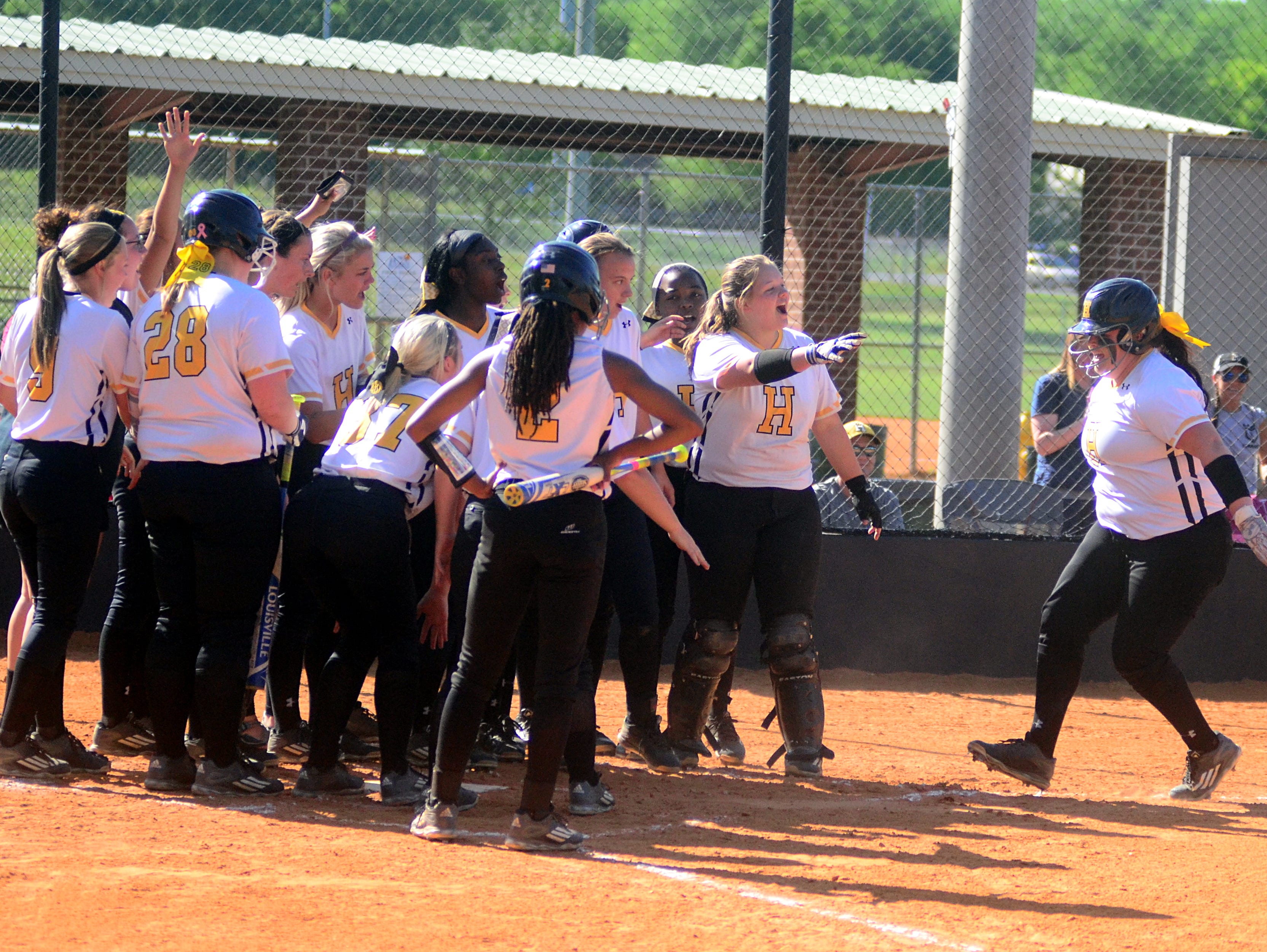 Hendersonville High teammates greet senior pitcher Carley Carlisle at home plate following her first-inning home run during Thursday afternoon’s contest against Portland. Carlisle homered twice and also collected nine strikeouts in earning the pitching victory.