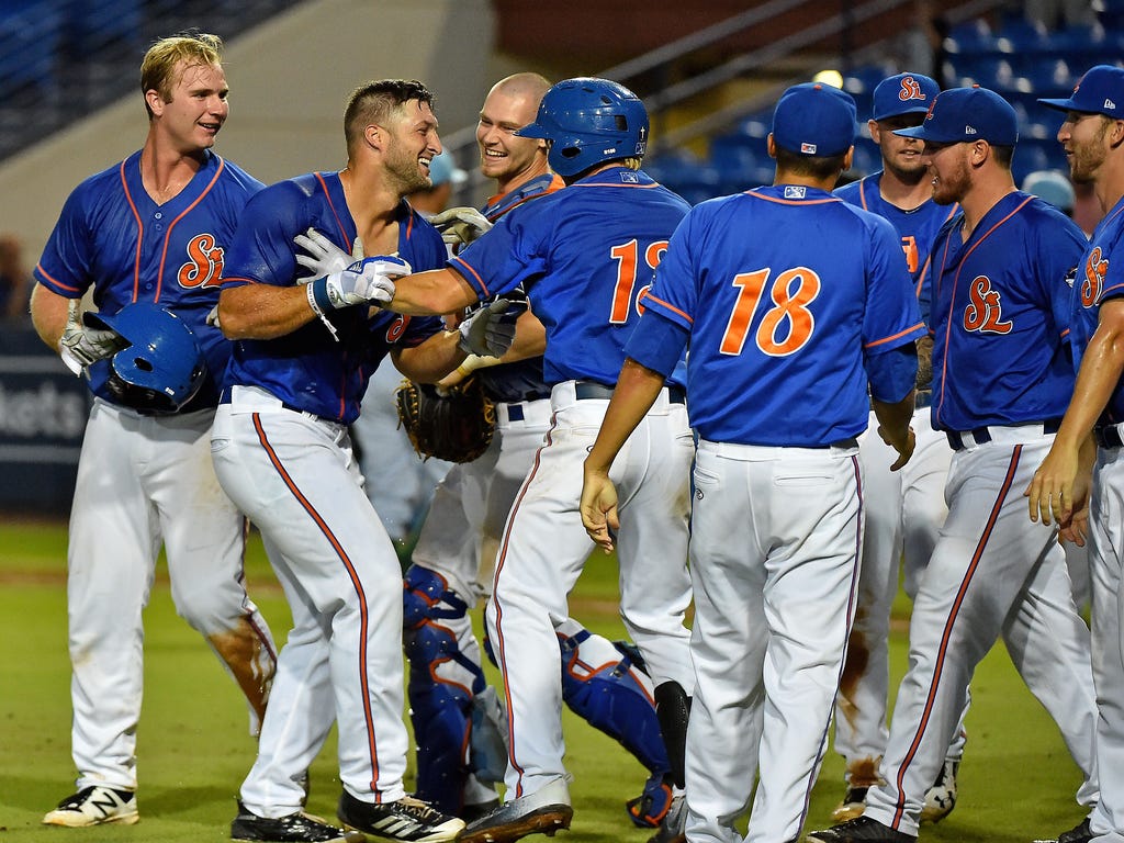 St. Lucie Mets designated hitter Tim Tebow is mobbed by teammates after hitting a walk-off solo home run to defeat the Daytona Tortugas in Port St. Lucie, Fla.