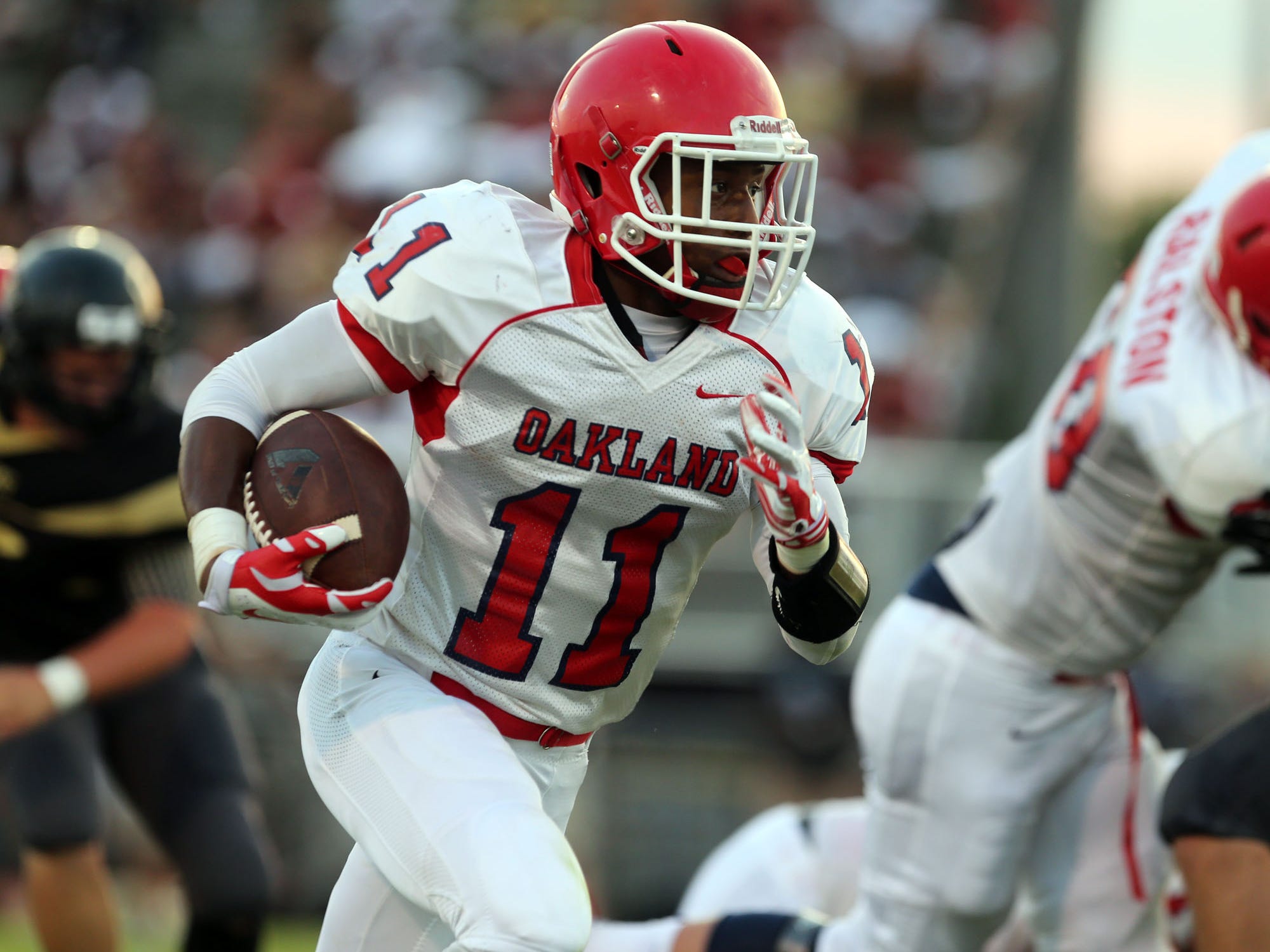Oakland's Josh Cunningham rushes against Mt. Juliet during the football jamboree Friday, August 15, 2014 at Smyrna High School.
