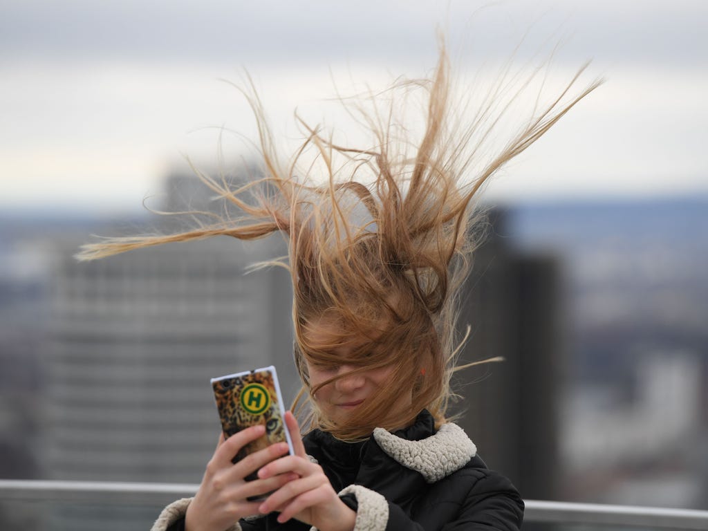 Elena from Dresden has her hair ruffled by the wind as she stands on a visitors' platform on the Maintower in Frankfurt Germany during stormy weather.