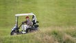 Trump drives his golf buggy during the second day of