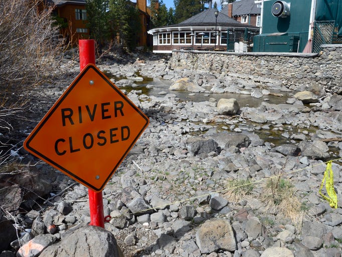 A 'River Closed' sign is posted on the Truckee River