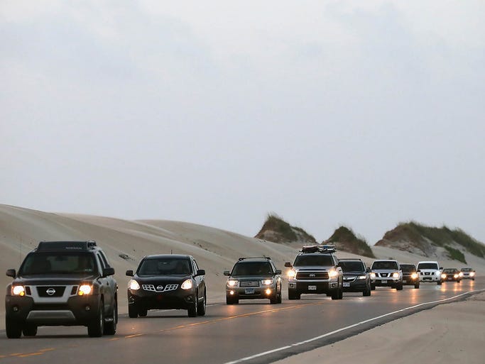 People evacuate the area on Highway 12 on Pea Island, N.C.