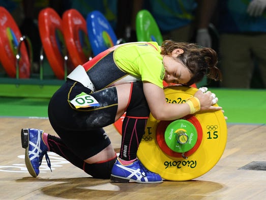 Hiromi Miyake (JPN) hugs the weights during the women's