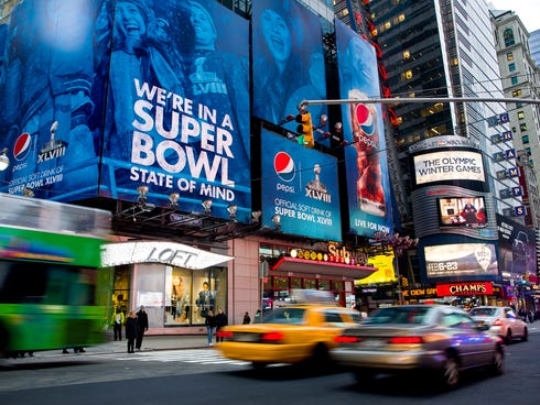 Large signs advertising the Super Bowl are seen on 42nd Street by Times Square, Monday, Jan. 20, 2014, in New York. Preparations for fan venues and activities for the upcoming Super Bowl are starting to appear along several blocks of Broadway, part o