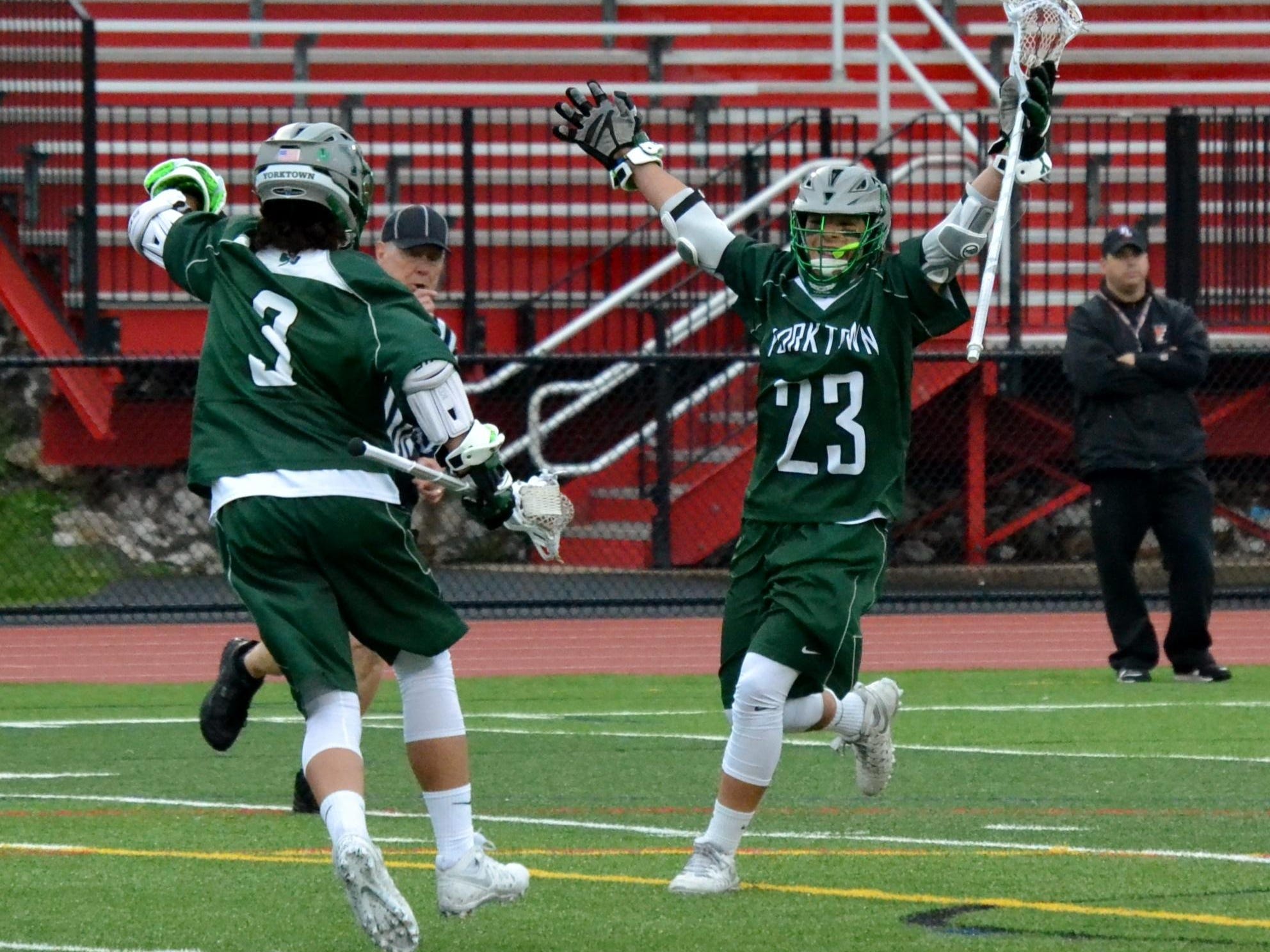 Hunter Embury (23) celebrates a third-period goal with his brother, Jamison. They each scored twice for Yorktown in an 8-6 win at Fox Lane on Tuesday.