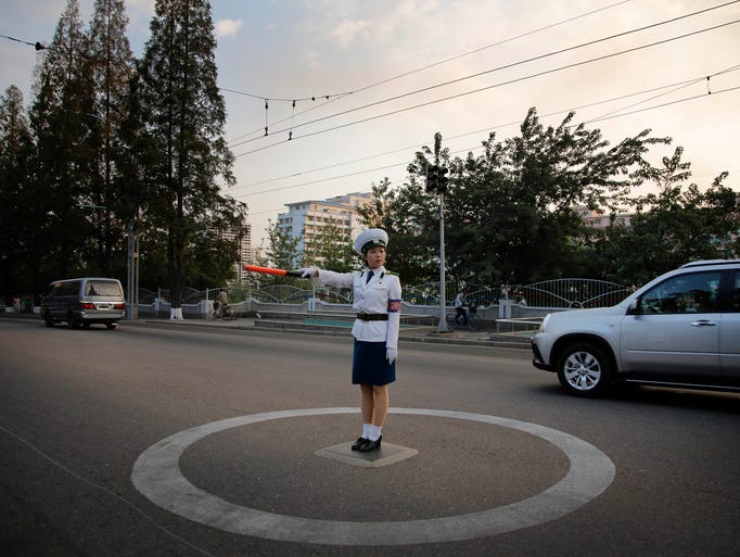 A North Korean traffic police woman directs vehicles